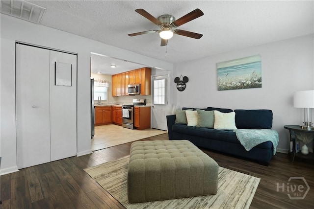 1504 Audubon Dr, Savannah, GA 31415 - living area with light wood finished floors, a ceiling fan, baseboards, and a textured ceiling