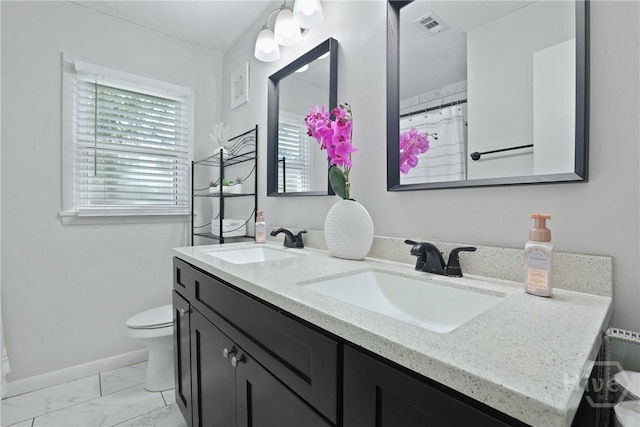 1504 Audubon Dr, Savannah, GA 31415 - full bath with double vanity, toilet, marble look tiles, and baseboards
