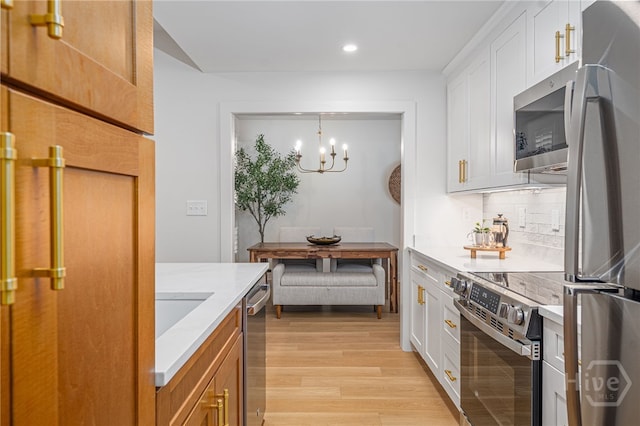 66 Dame Kathryn Dr, Savannah, GA 31411 - kitchen with appliances with stainless steel finishes, recessed lighting, light wood finished floors, decorative backsplash, and a chandelier