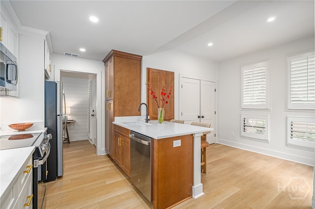 66 Dame Kathryn Dr, Savannah, GA 31411 - kitchen with stainless steel appliances, a sink, brown cabinets, a breakfast bar, and recessed lighting