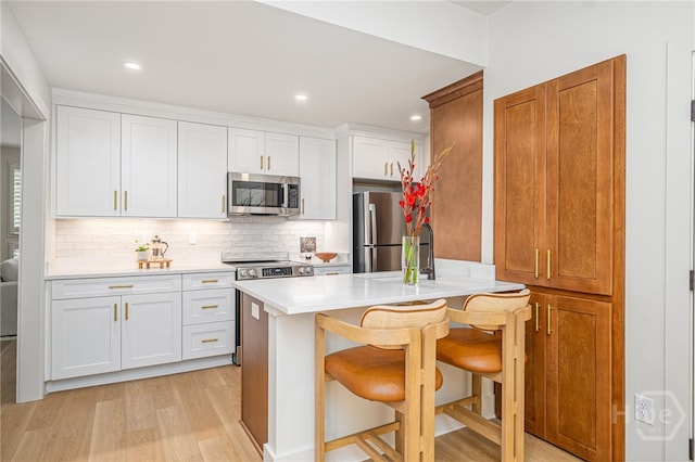 66 Dame Kathryn Dr, Savannah, GA 31411 - kitchen with appliances with stainless steel finishes, a breakfast bar area, light countertops, tasteful backsplash, and light wood finished floors