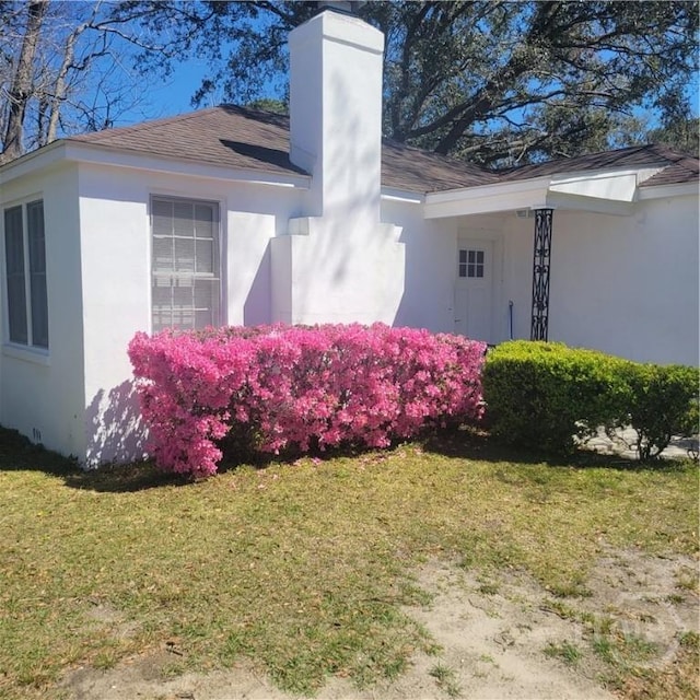 1214 Delesseps Ave, Savannah, GA 31404 - view of property exterior with a chimney, stucco siding, a yard, and roof with shingles