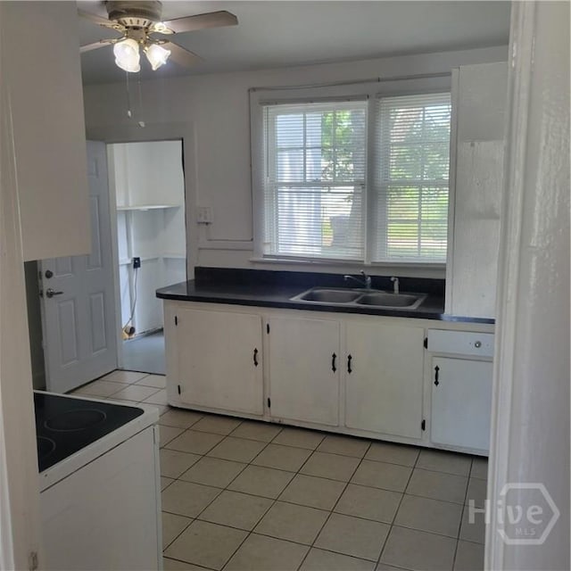 1214 Delesseps Ave, Savannah, GA 31404 - kitchen with white electric range oven, a sink, white cabinets, ceiling fan, and light tile patterned flooring