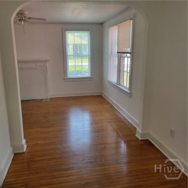 1214 Delesseps Ave, Savannah, GA 31404 - empty room with wood finished floors, arched walkways, ceiling fan, baseboards, and crown molding