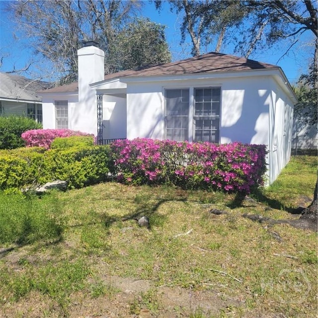 1214 Delesseps Ave, Savannah, GA 31404 - view of property exterior with a chimney, a yard, and stucco siding