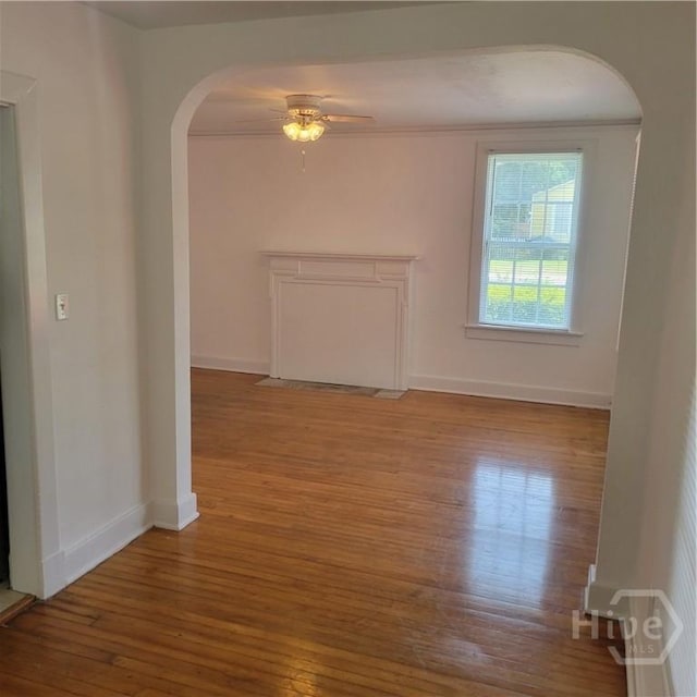 1214 Delesseps Ave, Savannah, GA 31404 - empty room with arched walkways, wood-type flooring, baseboards, and a ceiling fan