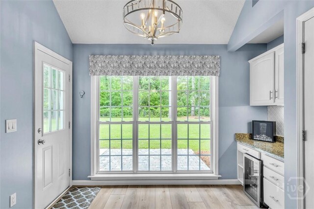 150 Laurenburg Dr, Richmond Hill, GA 31324 - doorway featuring baseboards, wine cooler, healthy amount of natural light, and vaulted ceiling