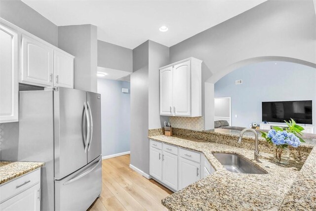 150 Laurenburg Dr, Richmond Hill, GA 31324 - kitchen featuring freestanding refrigerator, a sink, white cabinetry, light stone countertops, and recessed lighting