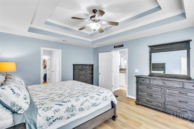150 Laurenburg Dr, Richmond Hill, GA 31324 - bedroom featuring a raised ceiling, light wood finished floors, baseboards, crown molding, and ceiling fan