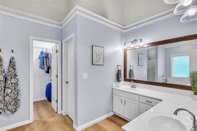150 Laurenburg Dr, Richmond Hill, GA 31324 - full bathroom featuring double vanity, crown molding, wood finished floors, a spacious closet, and baseboards