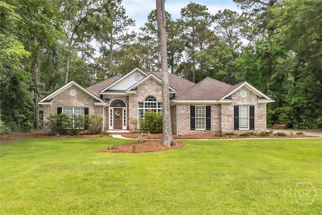 150 Laurenburg Dr, Richmond Hill, GA 31324 - view of front facade with brick siding, a front yard, and view of wooded area
