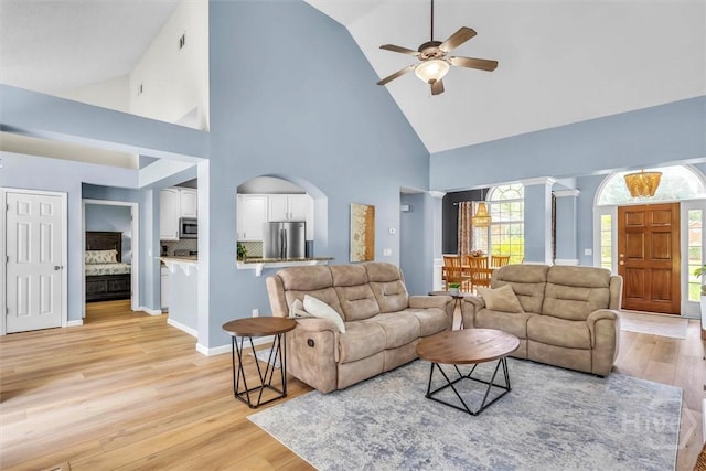 150 Laurenburg Dr, Richmond Hill, GA 31324 - living area with high vaulted ceiling, ceiling fan, light wood finished floors, arched walkways, and baseboards