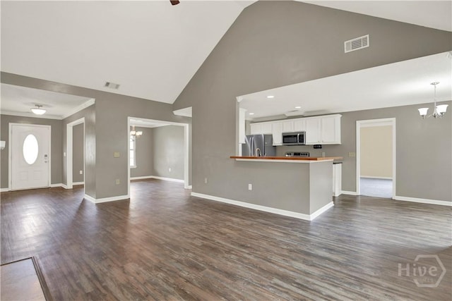 29 Joy Ln, Midway, GA 31320 - unfurnished living room featuring a chandelier, high vaulted ceiling, baseboards, dark wood-style floors, and crown molding