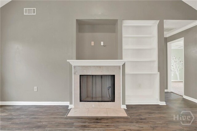 29 Joy Ln, Midway, GA 31320 - unfurnished living room with wood finished floors, baseboards, built in shelves, a fireplace with flush hearth, and crown molding