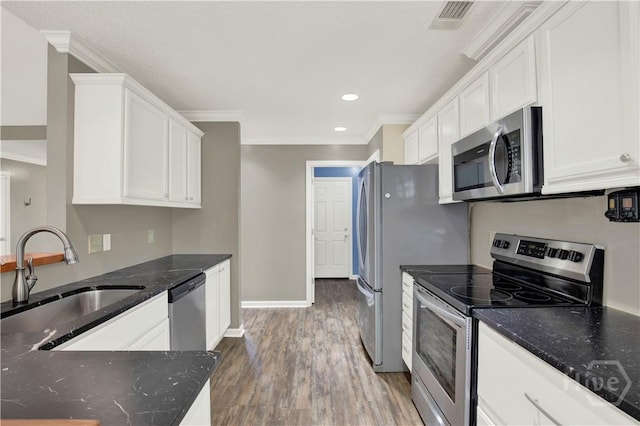 29 Joy Ln, Midway, GA 31320 - kitchen featuring stainless steel appliances, a sink, ornamental molding, white cabinetry, and wood finished floors