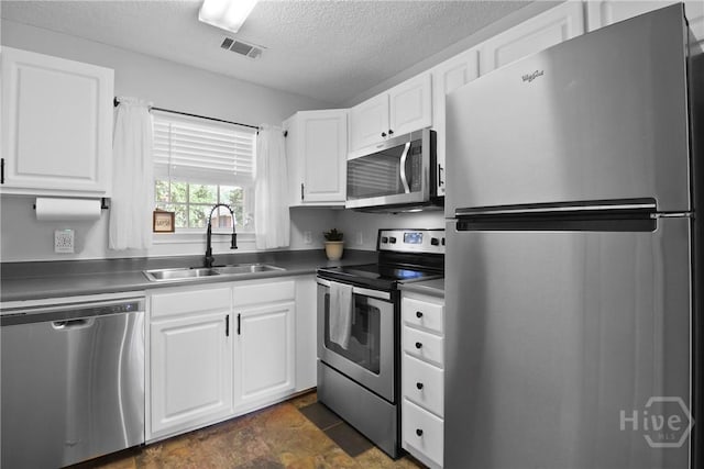 310 Tibet Ave Unit 10, Savannah, GA 31406 - kitchen featuring stainless steel appliances, a sink, a textured ceiling, white cabinetry, and dark countertops