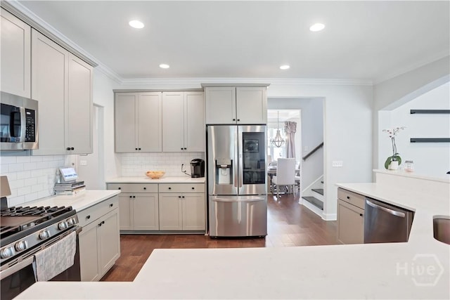 301 Highland Cir, Richmond Hill, GA 31324 - kitchen with stainless steel appliances, ornamental molding, dark wood finished floors, backsplash, and light countertops