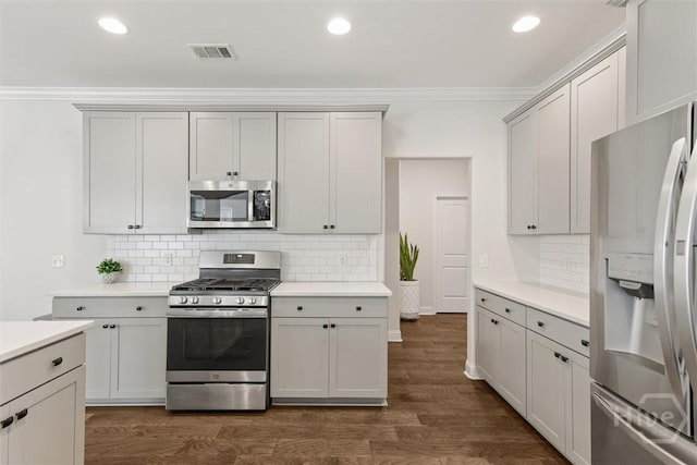 301 Highland Cir, Richmond Hill, GA 31324 - kitchen featuring stainless steel appliances, crown molding, decorative backsplash, dark wood-type flooring, and light countertops