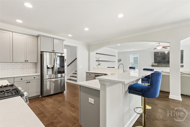 301 Highland Cir, Richmond Hill, GA 31324 - kitchen featuring stainless steel fridge, ornamental molding, arched walkways, gas stove, and tasteful backsplash