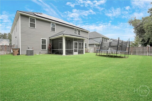301 Highland Cir, Richmond Hill, GA 31324 - back of house featuring a trampoline, central air condition unit, and a sunroom