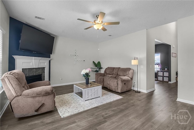 26 Sunflower Cir NE, Ludowici, GA 31316 - living area with ceiling fan, a fireplace, dark wood-style floors, and a textured ceiling