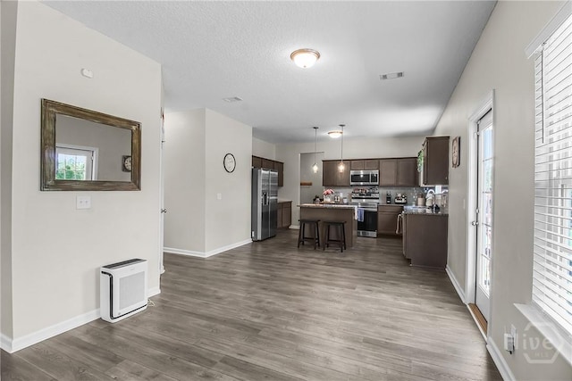 26 Sunflower Cir NE, Ludowici, GA 31316 - kitchen with stainless steel appliances, a center island, a kitchen breakfast bar, dark wood-style flooring, and baseboards