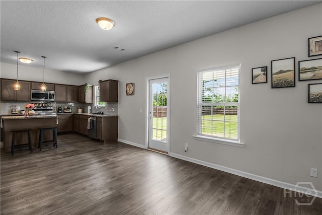 26 Sunflower Cir NE, Ludowici, GA 31316 - kitchen with appliances with stainless steel finishes, dark wood-style floors, a breakfast bar, baseboards, and backsplash