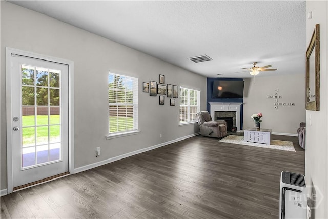 26 Sunflower Cir NE, Ludowici, GA 31316 - unfurnished living room with a fireplace, ceiling fan, wood finished floors, a textured ceiling, and baseboards