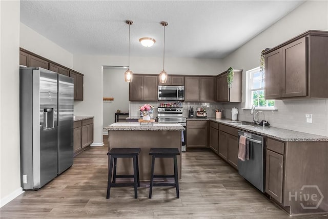 26 Sunflower Cir NE, Ludowici, GA 31316 - kitchen with stainless steel appliances, a center island, decorative backsplash, and wood finished floors