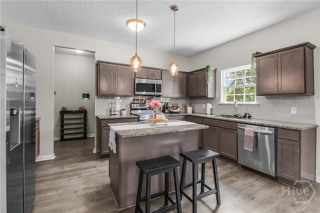 26 Sunflower Cir NE, Ludowici, GA 31316 - kitchen featuring stainless steel appliances, a sink, light wood finished floors, a kitchen island, and dark brown cabinetry
