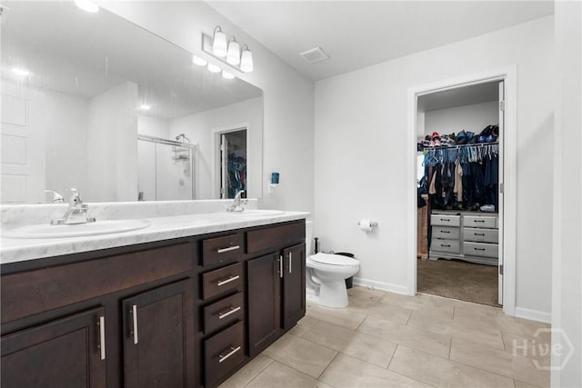 108 Franklins Walk, Rincon, GA 31326 - full bathroom featuring a walk in closet, double vanity, a stall shower, tile patterned floors, and toilet