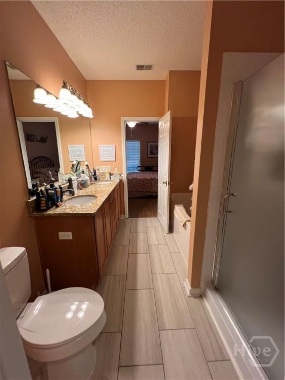 103 Travertine Cir, Savannah, GA 31419 - full bathroom featuring connected bathroom, toilet, a textured ceiling, double vanity, and an enclosed shower