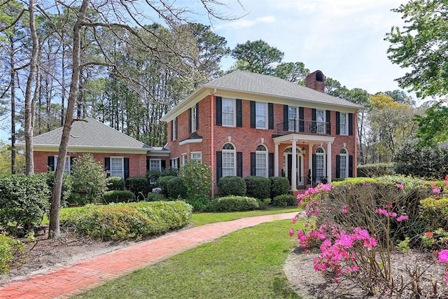 320 Wedgefield Xing, Savannah, GA 31405 - colonial home with brick siding, a chimney, a balcony, and a front yard