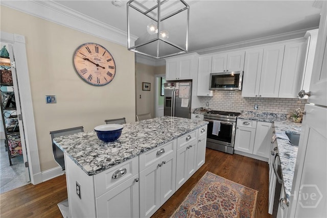 320 Wedgefield Xing, Savannah, GA 31405 - kitchen featuring stainless steel appliances, a kitchen island, dark wood-style floors, backsplash, and light stone counters