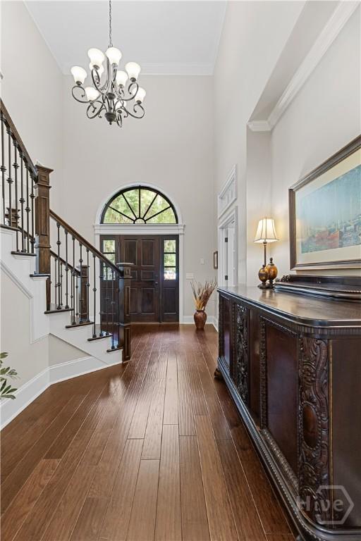 325 Shadow Moss Cir, Richmond Hill, GA 31324 - foyer with a chandelier, stairs, a towering ceiling, hardwood / wood-style floors, and ornamental molding