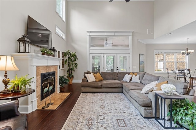 325 Shadow Moss Cir, Richmond Hill, GA 31324 - living room featuring a towering ceiling, dark wood finished floors, a fireplace, a ceiling fan, and a chandelier