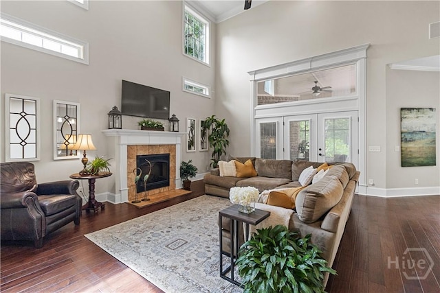 325 Shadow Moss Cir, Richmond Hill, GA 31324 - living area with ceiling fan, a high ceiling, crown molding, dark wood-style flooring, and a tile fireplace