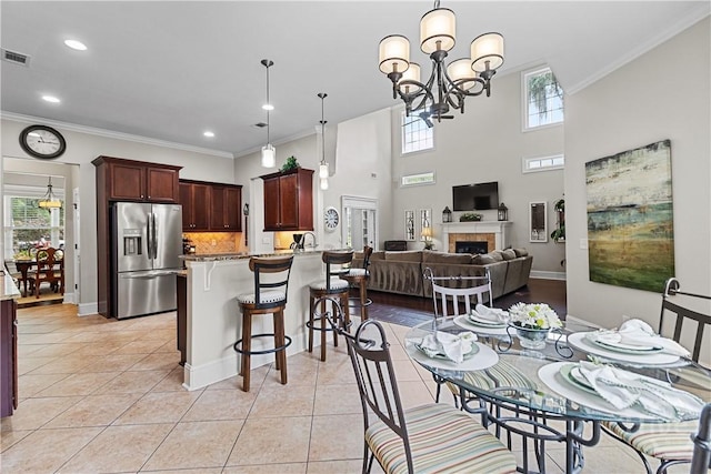 325 Shadow Moss Cir, Richmond Hill, GA 31324 - dining room featuring crown molding, light tile patterned flooring, a chandelier, a fireplace, and recessed lighting