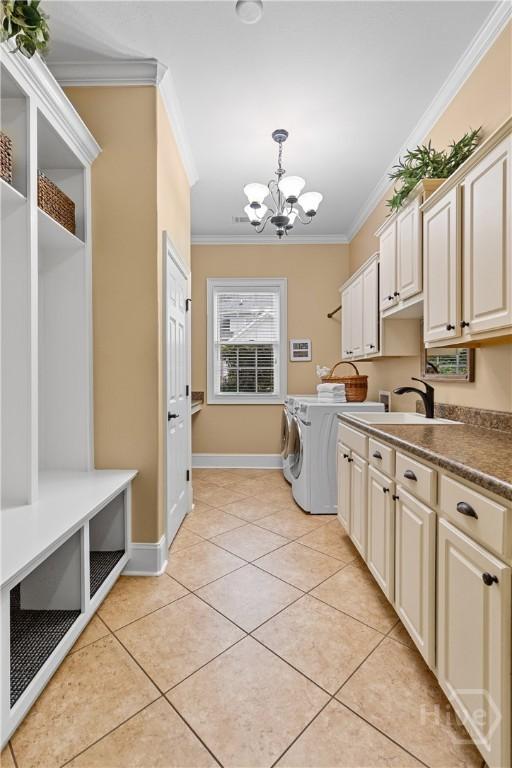 325 Shadow Moss Cir, Richmond Hill, GA 31324 - washroom featuring cabinet space, ornamental molding, a chandelier, washing machine and clothes dryer, and light tile patterned floors