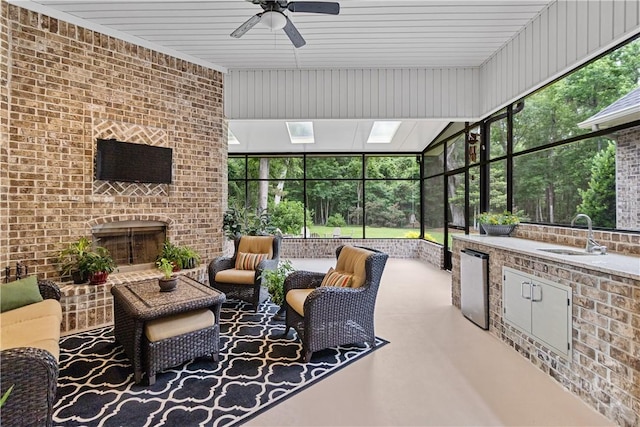 325 Shadow Moss Cir, Richmond Hill, GA 31324 - sunroom with an outdoor kitchen, ceiling fan, and an outdoor living space with a fireplace