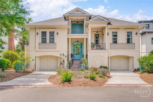 27 Mainsail Xing, Savannah, GA 31411 - view of front of home with concrete driveway, a balcony, a garage, and stucco siding