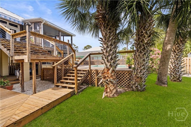 130 Lewis Ave, Tybee Island, GA 31328 - view of green lawn with a wooden deck, a pool, and stairway