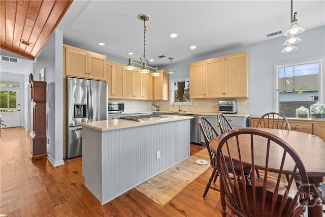130 Lewis Ave, Tybee Island, GA 31328 - kitchen featuring light brown cabinetry, appliances with stainless steel finishes, dark wood-type flooring, a sink, and plenty of natural light