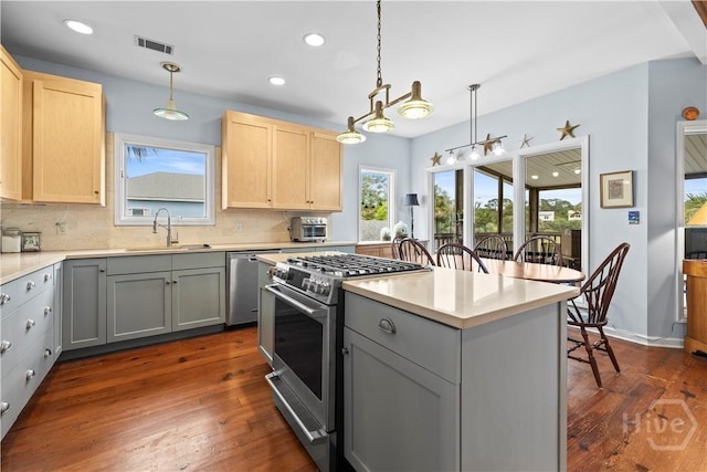130 Lewis Ave, Tybee Island, GA 31328 - kitchen featuring stainless steel appliances, a sink, light brown cabinets, gray cabinetry, and tasteful backsplash