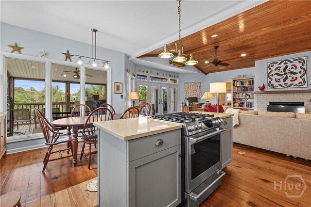 130 Lewis Ave, Tybee Island, GA 31328 - kitchen featuring stainless steel gas range, ceiling fan, gray cabinetry, hardwood / wood-style flooring, and hanging light fixtures