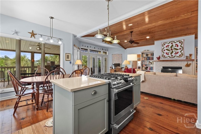 130 Lewis Ave, Tybee Island, GA 31328 - kitchen with stainless steel gas range, a ceiling fan, gray cabinets, a fireplace, and wood-type flooring