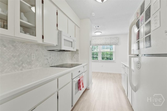4715 Oakview Dr, Savannah, GA 31405 - kitchen with white appliances, light wood-style flooring, tasteful backsplash, light countertops, and white cabinets
