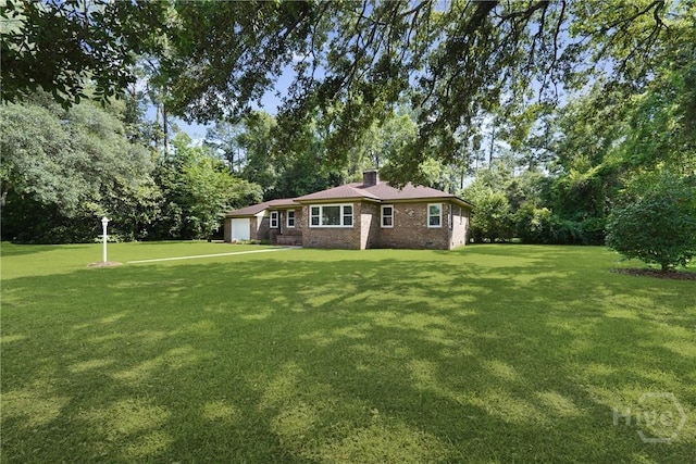 733 E Derenne Ave, Savannah, GA 31405 - view of front facade featuring a garage, a front lawn, brick siding, a chimney, and view of scattered trees