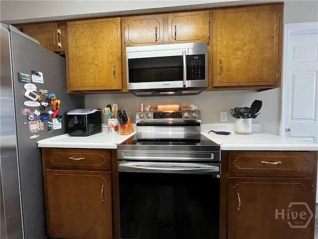 43 Fabian Ln, Hinesville, GA 31313 - kitchen with stainless steel appliances, light countertops, and brown cabinets