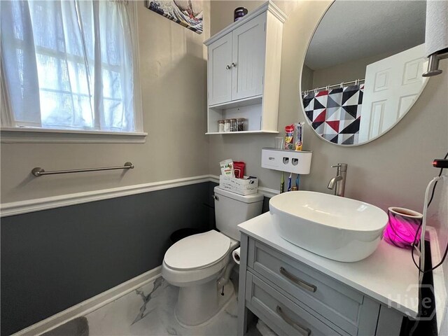 43 Fabian Ln, Hinesville, GA 31313 - bathroom with toilet, vanity, marble look tiles, and baseboards